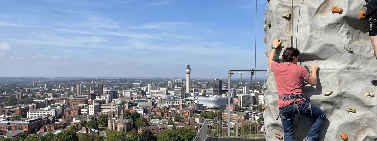 A climber on our mobile climbing wall high above Birmingham