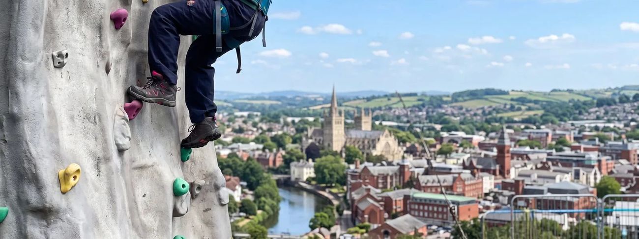 A climber on our mobile climbing wall high above Exeter