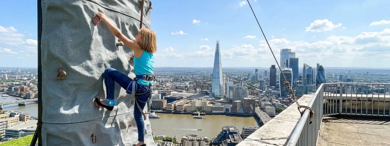 A climber on our mobile climbing wall high above London