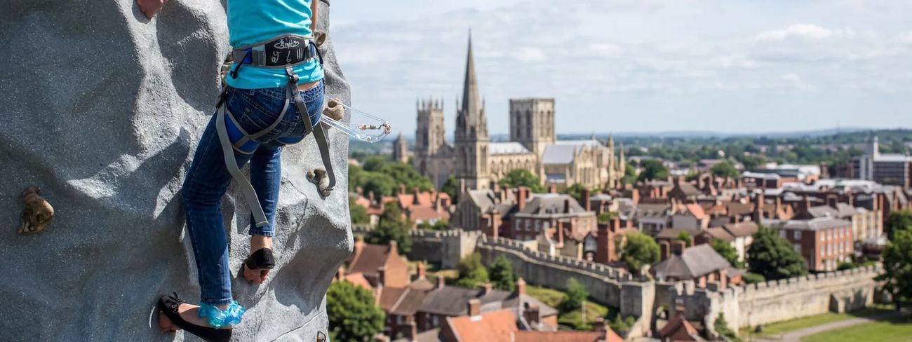 A climber on our mobile climbing wall high above York
